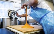 Oranje in Helmond. De Hema-bakkerij draaide in de aanloop naar Koningsdag een topproductie in het vervaardigen van tompoucen. beeld ANP, Rob Engelaar