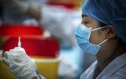 Ook China moest massaal gaan vaccineren om het coronavirus de baas te worden. Een gezondheidsmedewerker in Wuhan was er dit voorjaar nog druk doende mee. beeld AFP, STR