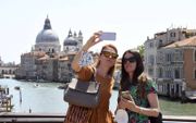 Toeristen in Venetië maken een selfie. beeld AFP, Andrea Pattaro