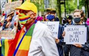 Betogers demonstreerden deze week bij het Homomonument in Amsterdam tegen een omstreden wet in Hongarije. Die wet wil voorlichting aan jongeren over homoseksualiteit aan banden leggen.  beeld ANP, Robin Utrecht