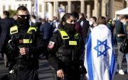 In bijzijn van agenten deed een vrouw vorige maand maand in Berlijn mee aan een pro-Israëlbetoging.  beeld EPA, Filip Singer