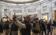 Oproerkraaiers met helmen en kogelwerende vesten bestormen op 6 januari het Capitool in Washington. beeld AFP, Saul Loeb