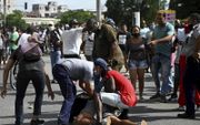 Een demonstrant wordt gearresteerd tijdens het protest tegen het communistische regime drie weken geleden in de Cubaanse hoofdstad Havana. beeld AFP, Yamil Lage