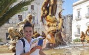 Johanne Hagendijk, reisleidster bij AmiGO, heeft ook in Sicilië haar reisgids bij de hand. beeld Joëlle van Zessen