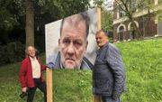 Fotograaf Ruud Spaargaren (l.) en voormalig dakloze Willem bij een bord waarop een portret van Willem is afgebeeld. beeld RD