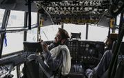Een talibanstrijder maakt een selfie in de cockpit van een buitgemaakt transporttoestel van de Afghaanse luchtmacht. beeld AFP, Wakil Kosar