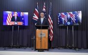 De Australische premier Scott Morrison (m.), donderdag tijdens een persconferentie over het Aukus-pact in Canberra. Links van hem op het scherm de Britse premier Boris Johnson, rechts de Amerikaanse president Joe Biden. beeld EPA, Mick Tsikas