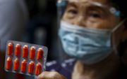 Een Filipijnse vrouw met ivermectine. Gebruik van het antiwormmiddel tegen corona is in Nederland verboden. beeld EPA, Rolex Dela Pena