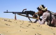Een soldaat in Jemen neemt een positie van Houthi-rebellen onder vuur. beeld AFP