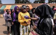 Keniaanse meisjes staan in de rij om maandverband te ontvangen. beeld AFP, Fredrik Lerneryd
