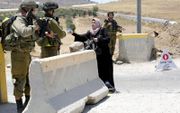 Mensenrechtenorganisaties betitelen de behandeling van Palestijnen door Israël steeds vaker als een vorm van apartheid. Maar die aantijging vindt geen steun in het internationaal recht. Foto: checkpoint in de buurt van Hebron. beeld EPA, Abed al-Haslamoun