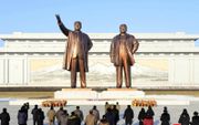 Noord-Koreanen leggen bloemen bij de standbeelden van de overleden leiders Kim Il Sung en Kim Jong Il. beeld AFP / KCNA via KNS