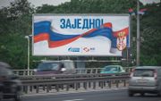 Auto's passeren een billboard met de Russische en Servische vlaggen met het cyrillische opschrift "Samen!" in Belgrado. beeld AFP, Andrej ISAKOVIC