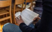 Een Iraanse asielzoeker leest de Bijbel. beeld RD, Henk Visscher
