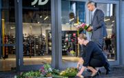 De Deense premier Mette Frederiksen (links) en minister van Justitie Mattias Tesfaye leggen bloemen bij het winkelcentrum waar een schutter zondag drie mensen doodde. beeld AFP, Mads Claus Rasmussen