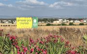 Op veel plaatsen in Israël geven grote borden op akkers aan dat de eigenaar van de grond zich houdt aan het sabbatsjaar. beeld Albert Groothedde