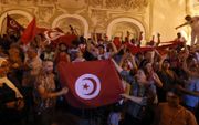 Aanhangers van de Tunesische president Kais Saied vieren de uitslag van het referendum over een nieuwe grondwet. beeld EPA, Mohamed Messara