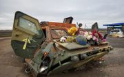 Een beschadigde Oekraïense pantserwagen met bloemen erop geplaatst door lokale mensen ter nagedachtenis aan de Oekraïense soldaten die stierven bij deze controlepost in de regio Charkiv. beeld EPA, Sergey Kozlov