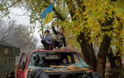 Een jongen zwaait in Cherson met een Oekraïense vlag. beeld AFP 