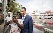 Franc Weerwind, minister voor Rechtsbescherming, maakt een selfie met een man op straat in Paramaribo. beeld ANP, BART MAAT