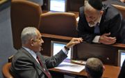 De Israëlische premier Benjamin Netanyahu spreekt met het Knesset (Israëlisch parlement) lid Aryeh Deri van de religieuze Haredi-partij Shas. beeld AFP, Gil Cohen-Magen