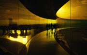 Mensen bezoeken in het ARoS Art Museum in het Deense Aarhus 'Your rainbow panorama' van de Deens-IJslandse kunstenaar Olafur Eliasson. 'Your rainbow panorama' is een permanent kunstwerk dat bestaat uit een cirkelvormige, 150 meter lange en 3 meter brede loopbrug van glas in alle kleuren van het kleurenspectrum. beeld AFP, Sergei GAPON