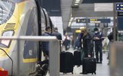 De trein is in veel gevallen een goed en duurzaam alternatief voor het vliegtuig. Foto: passagiers stappen aan boord van een Eurostar-trein op het St. Pancras station in Londen. beeld AFP, Tolga Akmen