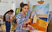 De 17-jarige Sedra leefde jaren lang in een tentenkamp, op de vlucht voor IS. Bij terugkeer wist ze wat ze  als eerste zou schilderen: een echt huisje. beeld Jaco Klamer