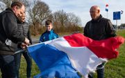 In heel Nederland hingen afgelopen maanden omgekeerde vlaggen. De verkiezingsuitslag geeft veel bezorgde boeren hoop. In het Overijsselse Nieuw Heeten bonden inwoners daarom de vlaggen weer goed aan stok. beeld Ruben Meijerink