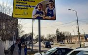 „Wij zijn in Brovary en zien onze toekomst in Oekraïne.” Ook in de oorlog gaat het werk onder jongeren met het syndroom van Down door, vertellen billboards in Brovary.   beeld familie Vasylenko