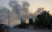 Donkere rookwolken boven Khartoem. Sinds zaterdag vinden er in de Sudanese hoofdstad hevige gevechten plaats. beeld AFP
