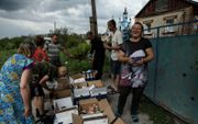 Oekraïners in de regio Donetsk delen eerste levensbehoeften met elkaar. beeld EPA, OLEG PETRASYUK