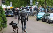 Een agent met politiehond begeeft zich naar de plaats des onheils, na de dodelijke steekpartij in het centrum van Leiden. beeld ANP Mediatv, Wouter Hoeben
