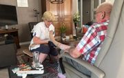 Wijkverpleegkundige Imka van Dusseldorp trekt de 80-jarige Barnevelder Gijs zijn steunkousen aan. beeld RD
