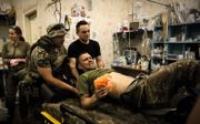 Artsen ontfermen zich over zwaargewonde Oekraïense militairen bij Bachmoet. De legerpredikanten Viktor Morozoek en Igor Rozvodovski bieden daar hulp. beeld EPA, Oleg Petrasyuk