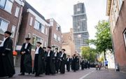 UU-hoogleraren in de binnenstad van Utrecht, op weg naar de Domkerk, die het Academiegebouw in de schaduw stelt. beeld ANP, Jeroen Jumelet