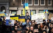Demonstranten betuigen steun aan Oekraïne na de inval van Rusland in het voorjaar van 2022. De protestactie op de Dam in Amsterdam werd georganiseerd door vredesorganisatie PAX. beeld ANP, Ramon van Flymen