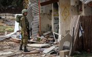 Een Israëlische militair in de kibboets Kfar Aza, waar Hamas dood en verderf zaaide. beeld AFP, Fadel Senna