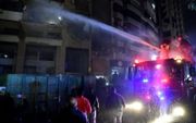 Libanese brandweerlieden blussen de brand die ontstond na de aanval op een gebouw in Beiroet waarbij Hamasleider Saleh al-Arouri om het leven kwam. beeld EPA, Abbas Salman