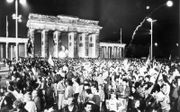 Feestvierders bij de Brandenburger Tor nadat de Berlijnse muur op 9 november 1989 is neergehaald. beeld Henk Visscher