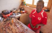 De gehandicapte Jorge cá Pai uit Guinee-Bissau verkoopt brilmonturen en verdient op die manier wat inkomen voor zijn gezin.  beeld Jaco Klamer