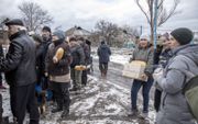 Buiten Avdiivka wachten burgers op brood dat hun wordt toegestopt door geestelijken van lokale kerken. beeld Anadolu, Narciso Contreras