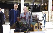 Wesley Sekewael (l.) en Dick Bakker bij een schaalmodel van de stoomhijskraan Schelde nummer 38, gemaakt door Bakker. beeld Van Scheyen Fotografie