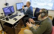 Psycholoog Maarten Vos demonstreert een behandelsessie met virtual reality.  beeld Sjaak Verboom