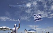 Israëliërs kijken donderdag op het strand van Tel Aviv naar een luchtshow van de Israëlische luchtmacht ter gelegenheid van de 71e Onafhankelijkheidsdag. Israël herdacht donderdag de het uitroepen van de moderne Joodse staat in 1948 door David Ben Goerion