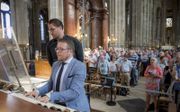 Samenzang met organist Minne Veldman in de Saint-Eustache van Parijs. beeld Raak Media, Matthias van Bloemendaal