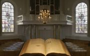 We zien een preekstoel met de Bijbel graag een centrale plaats in ons kerkgebouw houden.  beeld iStock