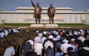 Noord-Koreanen buigen in Pyongyang voor de standbeelden van de Noord-Koreaanse oud-leiders Kim Il-sung en Kim Jong-il om de 25e sterfdag van de eerste te gedenken, maandag. beeld AFP, Kim Won-jin