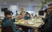 Kerkgangers zijn niet zelden actief als vrijwilliger, aldus het CBS. Archieffoto: maaltijd met vluchtelingen, georganiseerd door Utrechtse kerken. beeld Erik Kottier