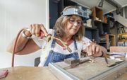 In haar edelsmidatelier voor in de winkel bewerkt Geartsje Dupon een gouden sieraad. beeld Jan Spoelstra